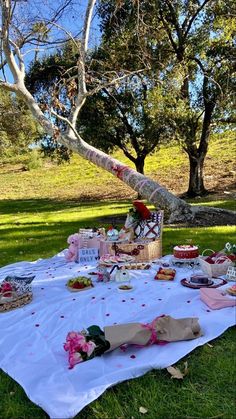 a picnic table is set up in the grass with food on it and flowers all around