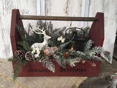 a wooden sled filled with pine cones and greenery on top of a table