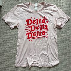 a white t - shirt with the words delta delta on it