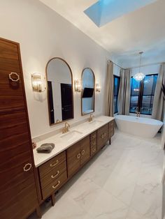 a large bathroom with two sinks and a bathtub in the middle of the room