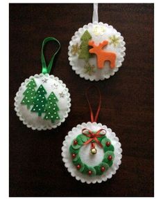 three christmas ornaments are hanging on a table