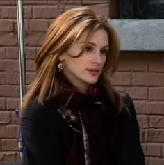 a woman standing in front of a brick wall