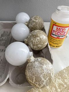 some white and gold ornaments are on a tray next to a bottle of foam soap