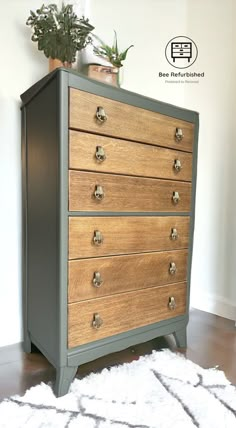 an old dresser has been painted gray and is next to a potted plant