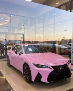 a pink car is parked in front of a window