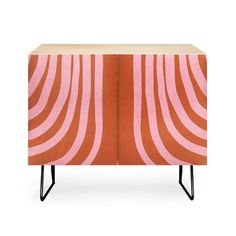 an orange and pink cabinet with black legs