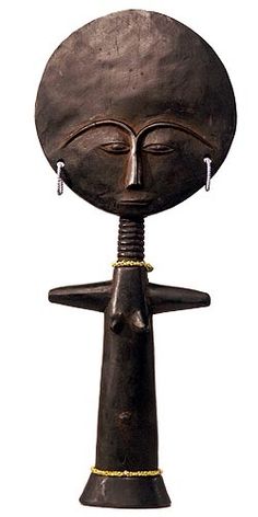 an african sculpture with a woman's head and two ear rings hanging from it