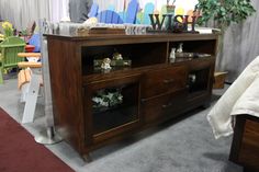 a wooden entertainment center sitting on top of a carpeted floor