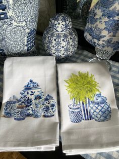 two blue and white vases sitting next to each other on top of a table