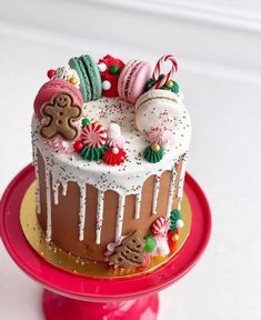 a decorated cake sitting on top of a red plate covered in icing and candies