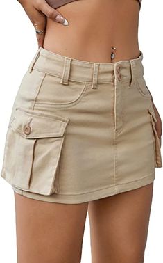 a woman wearing a tan top and khaki shorts with her hand on her hip