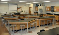 an empty classroom with desks and stools