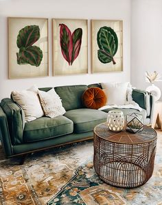 a living room with two paintings on the wall and a coffee table in front of it