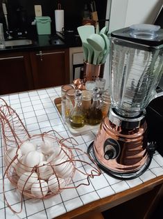 an electric blender sitting on top of a counter next to other kitchen utensils