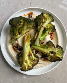 broccoli florets and hummus on a white plate