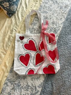 a red and white bag sitting on top of a bed