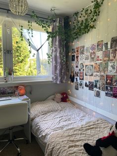 a bedroom with a bed, desk and window covered in photos on the wall next to it