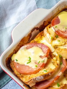 a casserole dish with ham, cheese and tomatoes in it on a blue towel