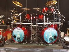 a red and blue drum set on display in a room with other musical equipment around it