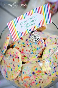 a glass bowl filled with cookies and sprinkles on top of a table