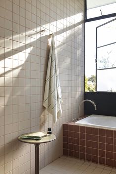 a bath room with a tub and a towel hanging on the wall next to it