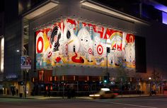 a large building with lots of colorful paintings on it's side at night time