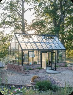 a glass house in the middle of a garden