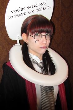 a woman wearing glasses and a neck tie with a sign on her head that says, you're welcome to share my toilet