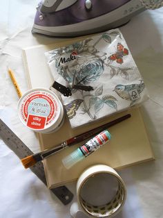 an iron, measuring tape, and other crafting supplies are laid out on a sheet of paper