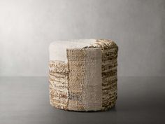 a stool made out of woven material on top of a gray surface with a light colored background