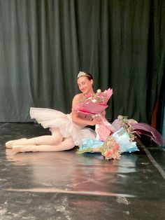 a ballerina is sitting on the floor with flowers