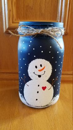 a blue jar with a snowman painted on it