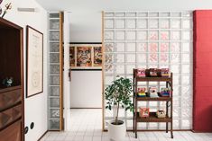 a living room with white tile floors and red walls, along with a book shelf filled with books