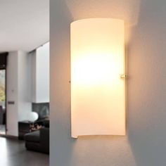 a wall light mounted on the side of a white wall next to a living room