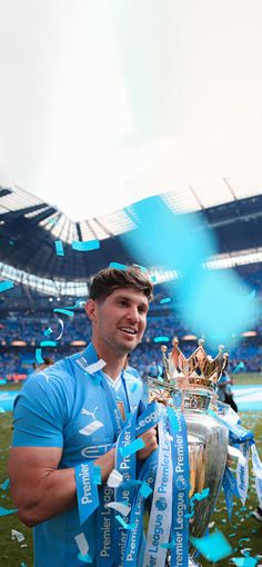 a man holding a trophy and confetti in front of him on the field