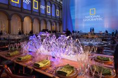 a long table with plates and glasses on it in front of a large projection screen