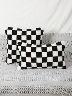 two black and white pillows sitting on top of a bed