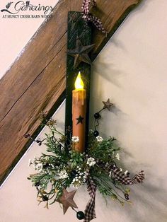 a lighted candle hanging from the side of a wall with flowers and stars on it