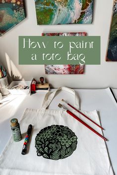 a white bag sitting on top of a table next to some paint and pencils