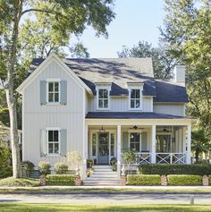 a large white house with lots of windows and shutters on the front door is shown