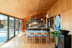 a dining room and kitchen area with wood paneling on the walls, hardwood floors, and sliding glass doors