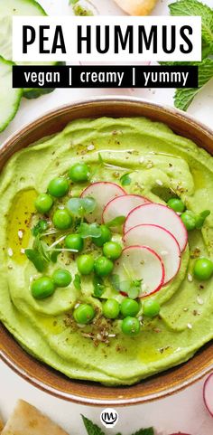 pea hummus in a bowl with radishes and cucumbers on the side