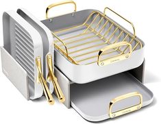 two trays with gold handles are stacked on top of each other in front of a white background