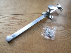 a pair of metal handles sitting on top of a wooden table next to a plastic bag