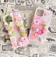 two cell phones sitting on top of a table covered in paper and plastic flower decorations