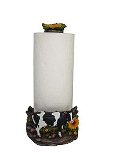 a toilet paper holder with a cow and flowers on it's top, holding a roll of toilet paper