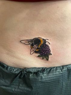 a woman with a bee tattoo on her stomach