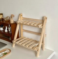 a wooden shelf sitting on top of a desk next to a laptop