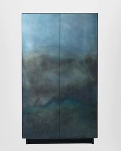 an abstract painting with blue and green colors on the side of a cabinet in front of a white wall