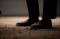 a person standing on the ground wearing black shoes